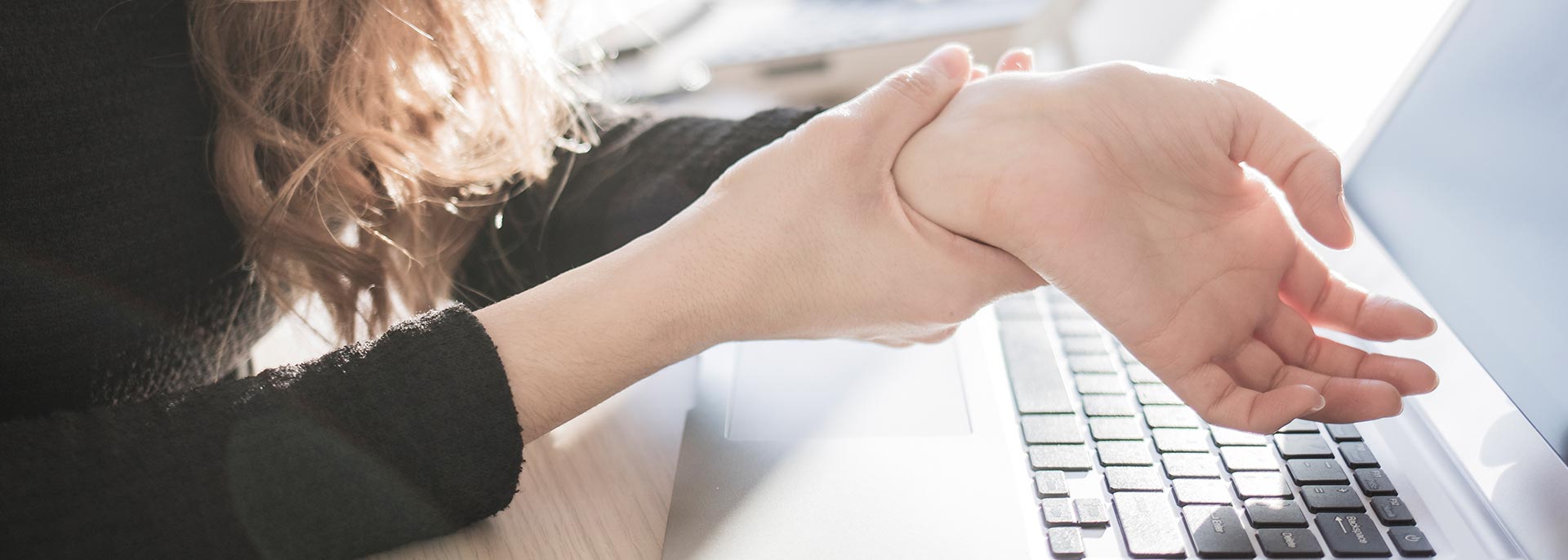 Woman with repetitive strain injury from poor workstation setup